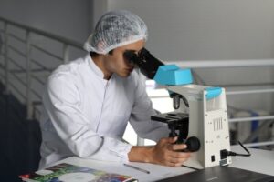 ERP Epicor consultants for medical research industries, lab technician looking under microscope